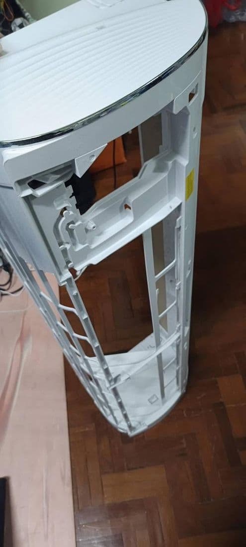 ตัวเครื่องแอร์ถอดลงมาวางบนพื้นไม้ เห็นโครงด้านในและช่องพัดลมทั้งแนว