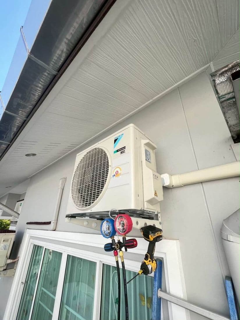 คอยล์ร้อนใหม่ติดบนขายึดใต้ชายคา มีชุดเกจวัดน้ำยาต่ออยู่ระหว่างทดสอบ