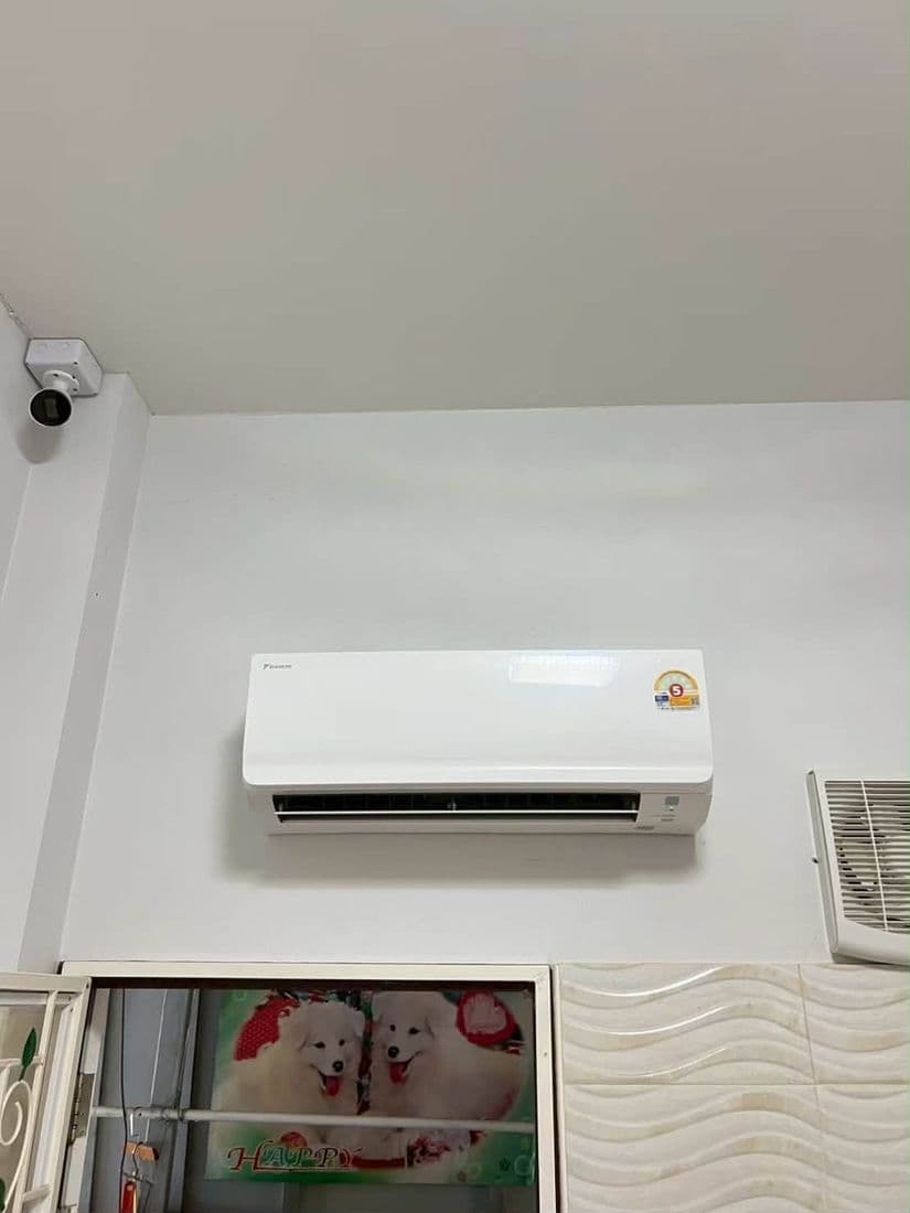 แอร์ติดผนังเครื่องใหม่บนผนังห้อง มีกล้องวงจรปิดติดอยู่ตรงมุมเพดาน
