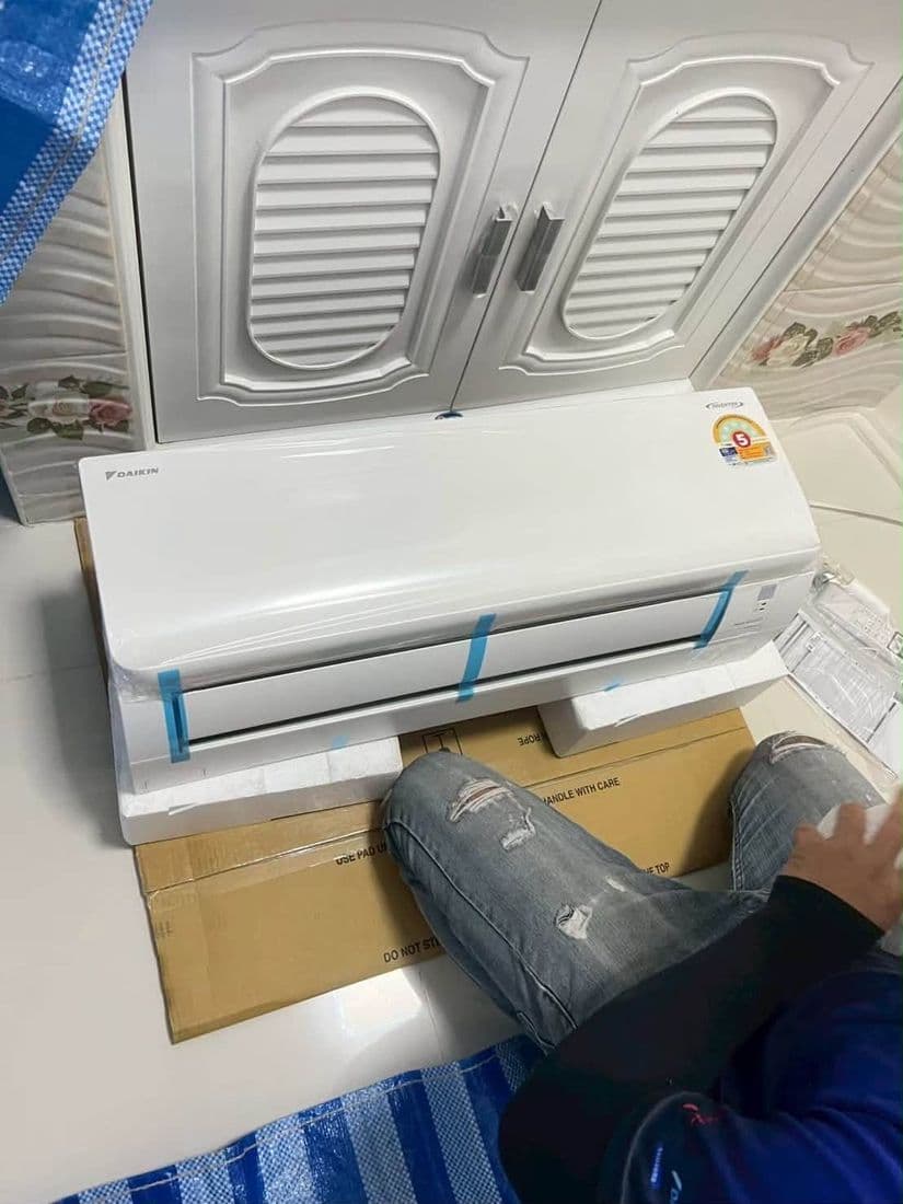 เครื่องแอร์ใหม่ยังหุ้มพลาสติกวางบนกล่องกระดาษ ระหว่างเตรียมยกขึ้นติดผนัง