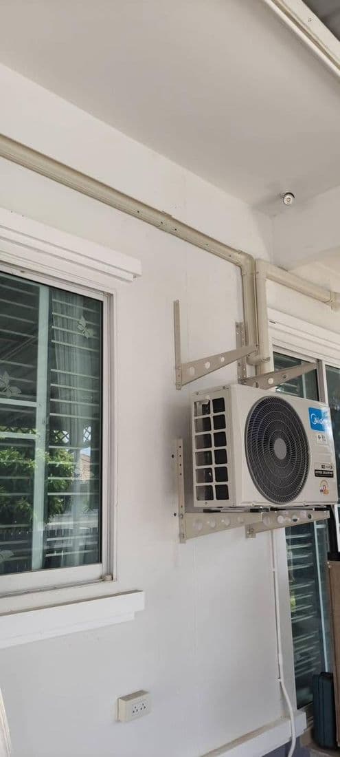 คอยล์ร้อนแขวนบนขายึดข้างหน้าต่าง มีรางครอบท่อเดินลงมาตามแนวผนัง