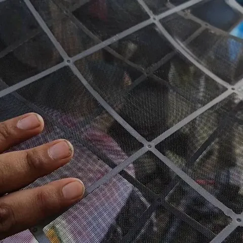 A washed filter screen held up against the light, clear enough to see straight through the mesh