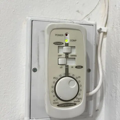 กล่องควบคุมแอร์แบบปุ่มหมุนที่ติดตั้งไว้ มีสายไฟเดินขึ้นไปด้านบน