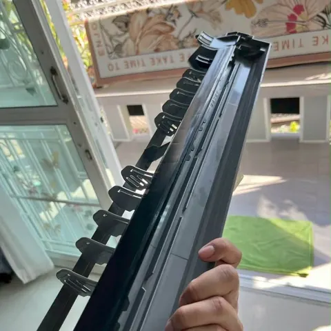 มือยกชุดใบพัดโบลเวอร์สีดำขึ้นดู เห็นซี่ใบพัดเรียงตลอดแนว