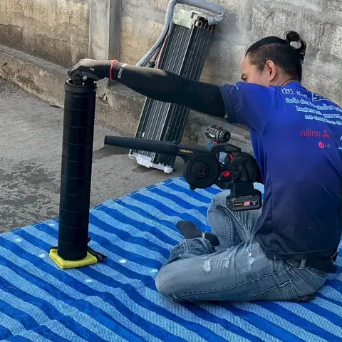 ช่างนั่งฉีดน้ำล้างชุดใบพัดโบลเวอร์ที่ตั้งเตรียมไว้ให้ทั่วซี่ใบ