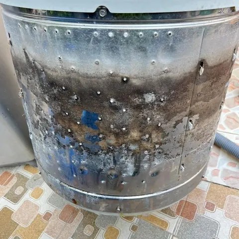 ถังสเตนเลสที่ล้างผิวบนแล้วแต่ช่วงล่างยังมีคราบดำเปรอะเป็นแนวรอบใบ