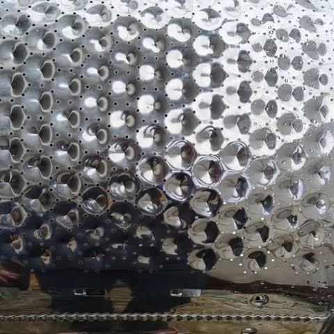 ถังซักที่ล้างแล้วเอียงพิงอยู่ เห็นรูระบายนูนเรียงเป็นแถวถี่