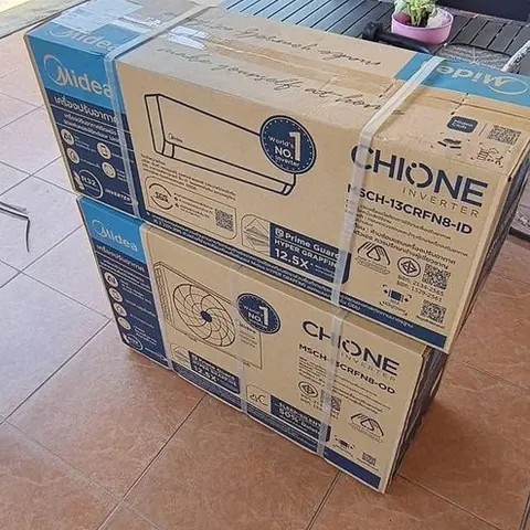 กล่องเครื่องปรับอากาศใหม่สองกล่องวางซ้อนกันรอยกเข้าไปที่หน้างาน