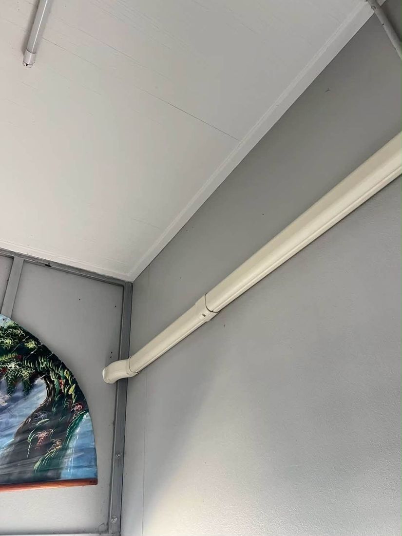 Refrigerant pipes running neatly inside a white trunking cover along the corner of a room wall